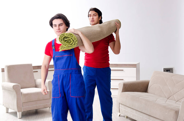 Two young contractor employees moving personal belongings  - Foto, afbeelding
