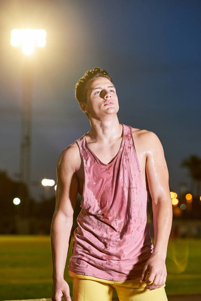 Portrait of a young muscular sweat sportsman posing on stadium - Φωτογραφία, εικόνα