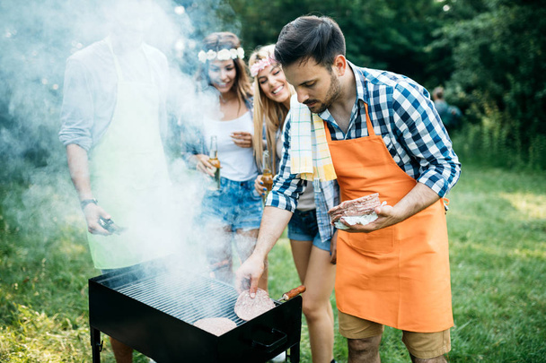 Friends having fun grilling meat enjoying bbq party - Photo, Image