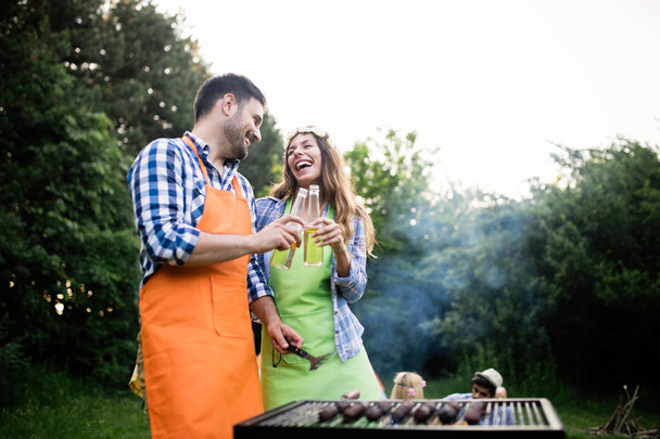 Group of friends having outdoor barbecue laughing together - Photo, image