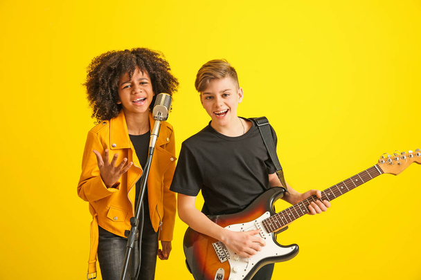 Teenage musicians playing against color background - Foto, imagen