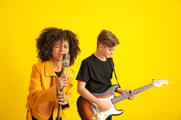 Teenage musicians playing against color background - Foto, Imagen