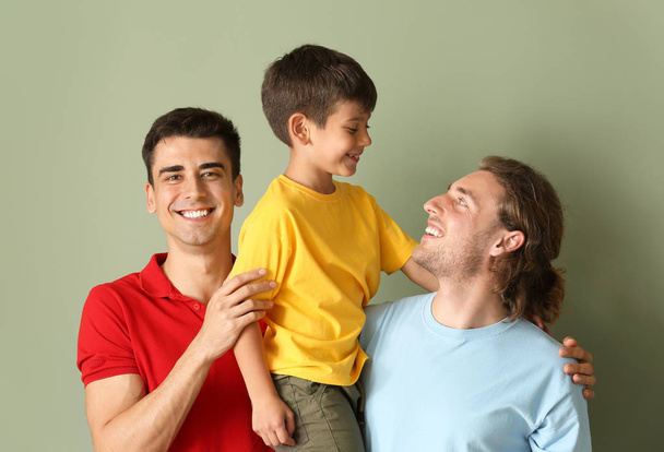 gelukkig gay paar met geadopteerd kind op kleur achtergrond - Foto, afbeelding
