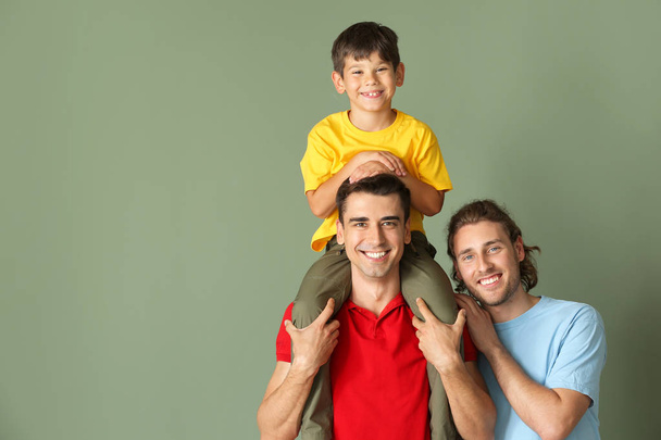 gelukkig gay paar met geadopteerd kind op kleur achtergrond - Foto, afbeelding