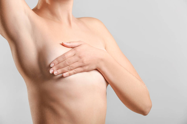 Mujer desnuda sobre fondo gris. Concepto de aumento de senos
 - Foto, Imagen