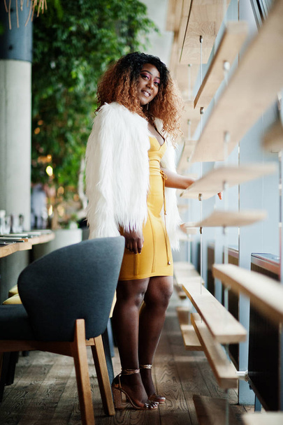 Glamour african american woman in yellow dress and white woolen  - Fotoğraf, Görsel