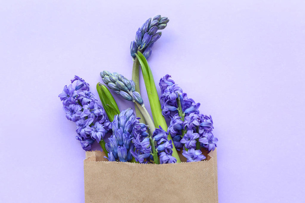 Bag with beautiful hyacinth flowers on color background - Фото, зображення