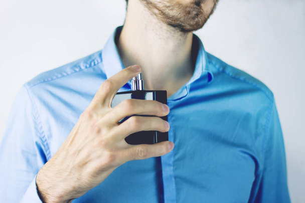 The man sprinkles himself on perfume - Foto, imagen