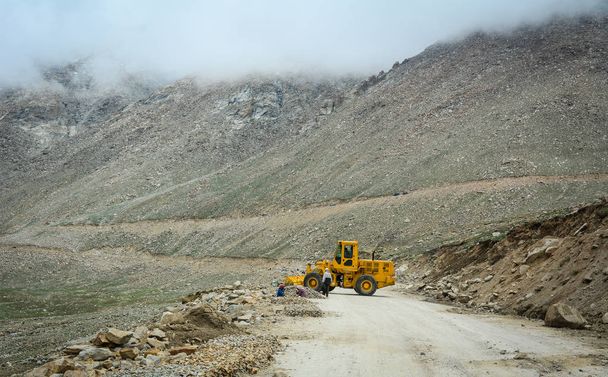 Ladakh, India - 18 de julio de 2015. Una máquina cargadora de excavadoras que trabaja en carretera de montaña en Ladakh, India
. - Foto, imagen