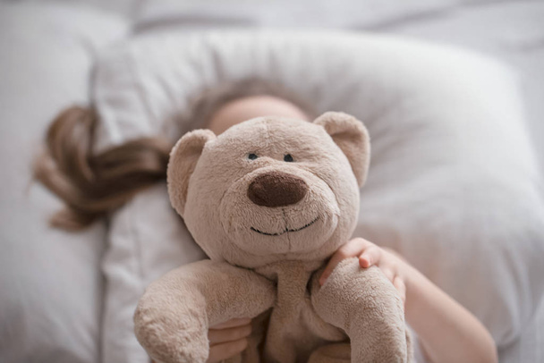 Little cute girl in bed with toy - Фото, зображення
