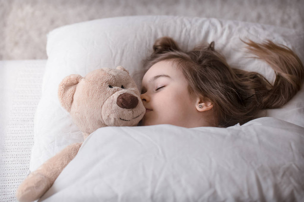 Niña linda en la cama con juguete
 - Foto, Imagen