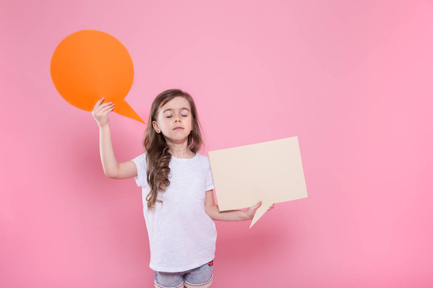 Cute little girl with an icon of a speech on a pink background - Photo, Image