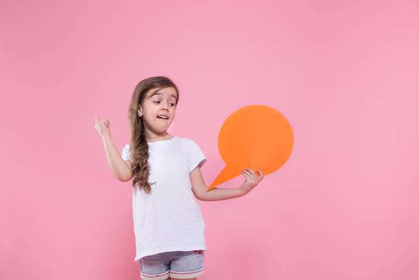 Aranyos kislány egy ikont a beszéd a rózsaszín háttér - Fotó, kép