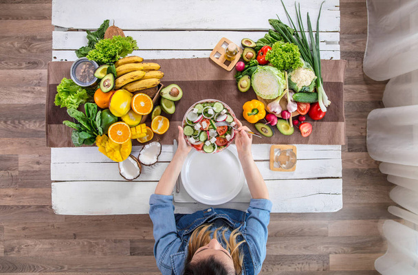 Женщина за обеденным столом с органическими продуктами, вид сверху
. - Фото, изображение