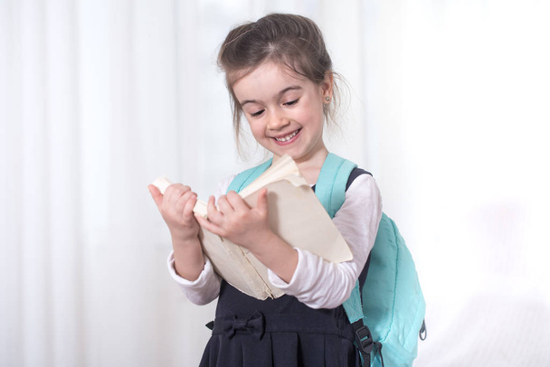 Κορίτσι-δημοτικό σχολείο μαθητής με ένα σακίδιο και ένα βιβλίο - Φωτογραφία, εικόνα