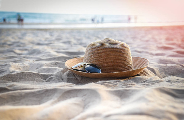 klobouček letní-slaměný klobouk a příslušenství pro sluneční brýle na písku - Fotografie, Obrázek