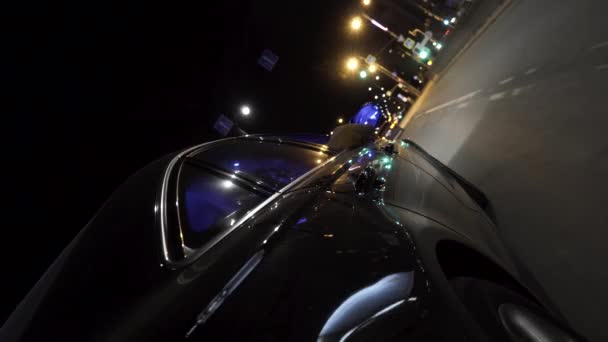 De nacht auto rijden in de late avond tijd, uitzicht vanaf het wiel, nachtleven concept. Beelden. Close-up voor bewegende zwarte auto door de Night City Street. - Video