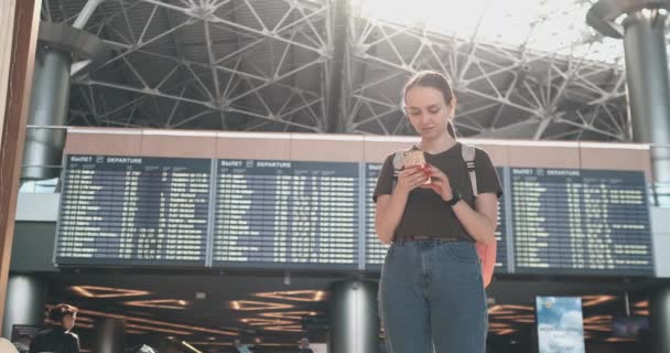 Jonge mooie vrouw op het vliegveld schrijft een bericht - Video
