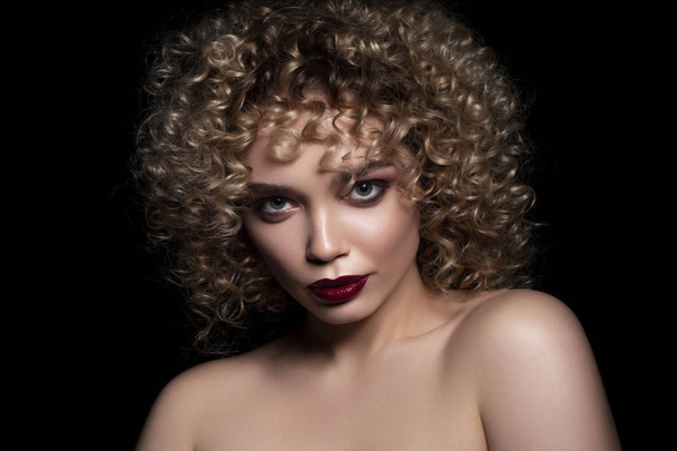 Cute caucasian woman with afro (curls) hairstyle on a dark backg - Foto, afbeelding