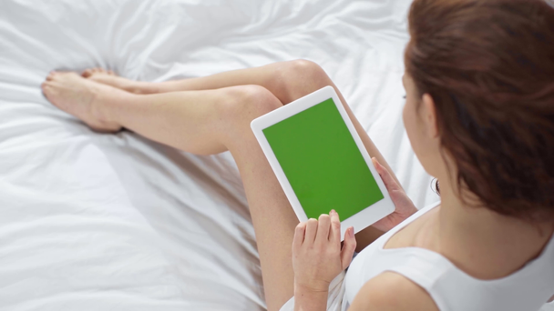 lány az ágyban a digitális tabletta zöld képernyő otthon - Felvétel, videó