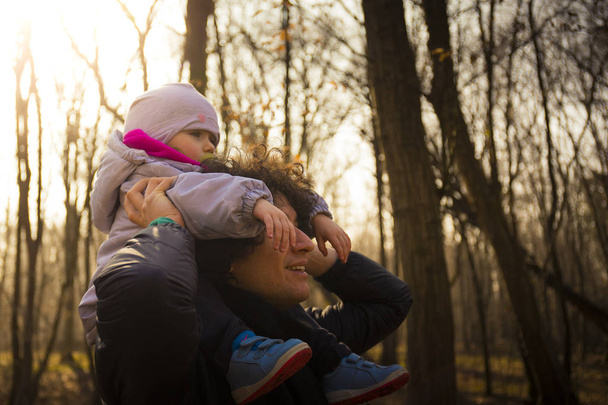 Papà che porta il suo bambino sulle spalle nella foresta
 - Foto, immagini