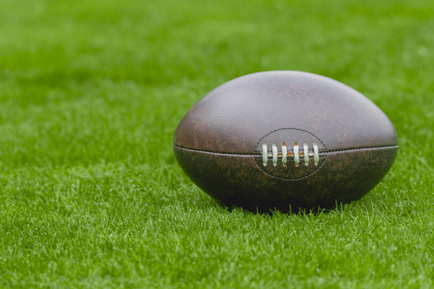 American football, rugby ball on green grass field background - Photo, Image