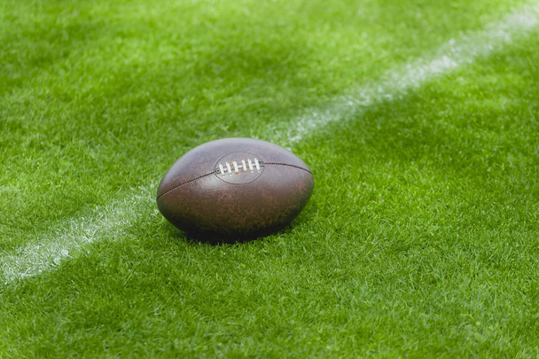 Американский футбол, регби мяч на зеленом фоне травы
 - Фото, изображение