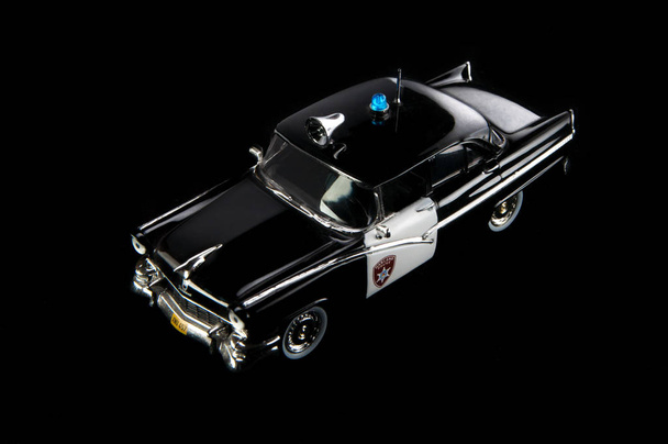 Giocattolo nero, modello in plastica dell'auto della polizia. Fondo nero
 - Foto, immagini