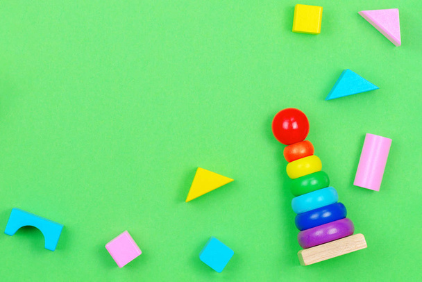 Kids játékok háttér keret baba egymásra gyűrűk piramis és színes blokkok zöld háttér - Fotó, kép