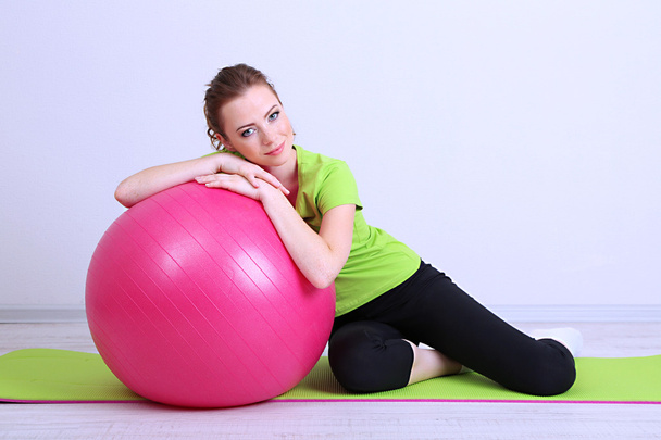 Portrait of beautiful young woman exercises with gym ball - Foto, Imagen