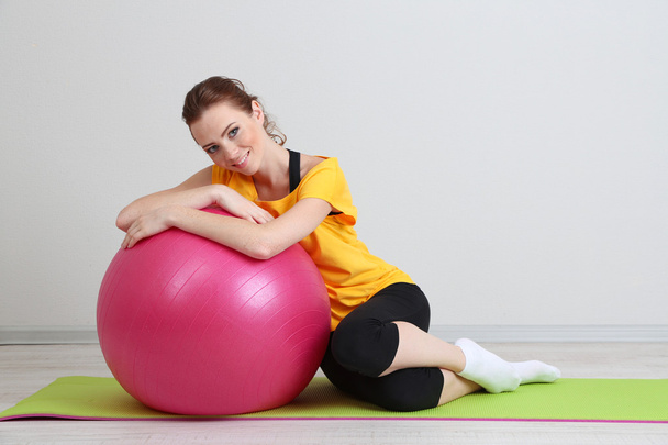 Portrait of beautiful young woman exercises with gym ball - Foto, imagen