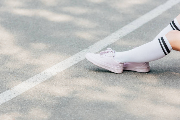 yolda oturan beyaz diz çorap kız kısmi görünümü - Fotoğraf, Görsel