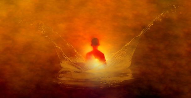 Image orange d'une silhouette méditante dans une éclaboussure d'eau
 - Photo, image