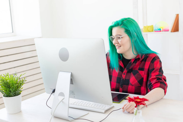 Business, designer and animator concept - young woman illustrator or artist with green hair draws on the graphic tablet - Photo, image