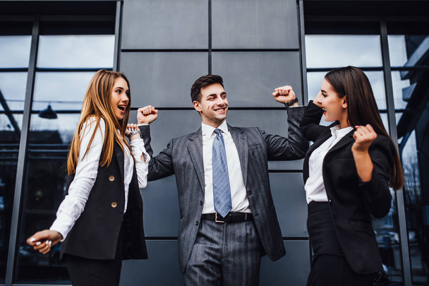 Счастливые бизнесмены с поднятыми руками выигрывают финансовую конкуренцию
 - Фото, изображение