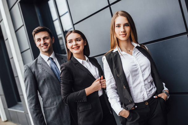 Group of young businessman and businesswomen standing near office - Фото, изображение