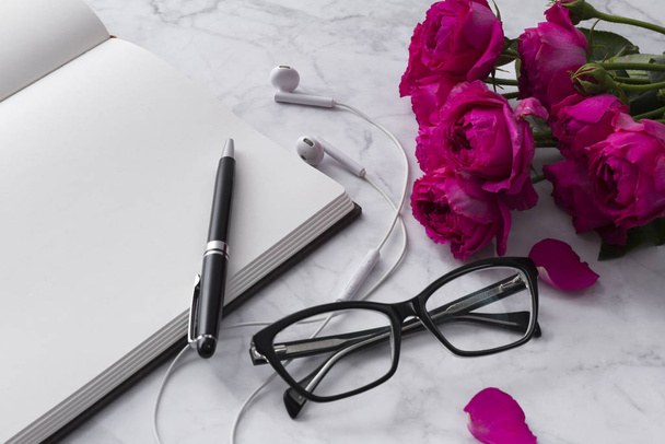 Headphones, glasses and roses bouquet with blank notepad on white background - Foto, Bild