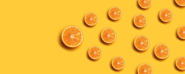 Kreativní Letní vzorek vyrobený z čerstvých oranžových řezů na žlutém pozadí. - Fotografie, Obrázek