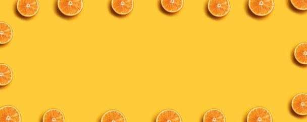 黄色の背景に新鮮なオレンジ色のスライスのフルーツパターン. - 写真・画像