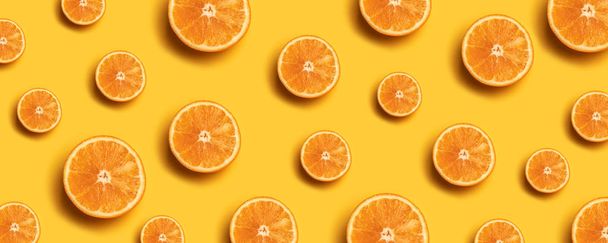 Δημιουργικό καλοκαιρινό μοτίβο φτιαγμένο από φρέσκες φέτες πορτοκαλιού σε κίτρινο φόντο. - Φωτογραφία, εικόνα