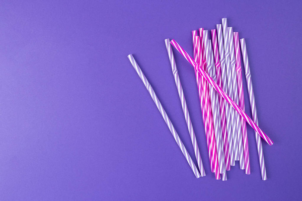 Multi Colored drinking straws on purple background - Photo, Image