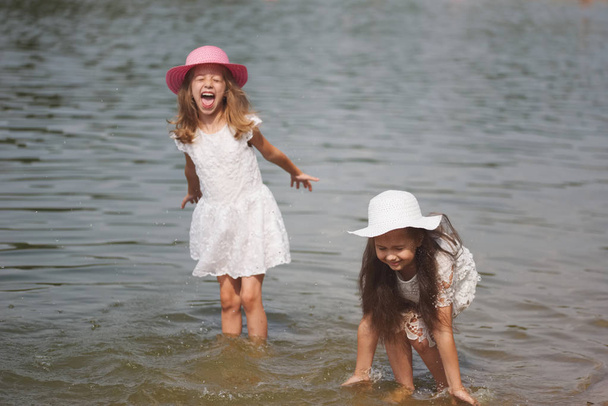 cute happy little girls in sumer lake - Φωτογραφία, εικόνα