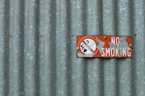 Peeling rouge et blanc Panneau non-fumeur sur fer ondulé
 - Photo, image