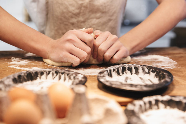 Close up of a woman wearing apron preparing dough - Foto, Bild