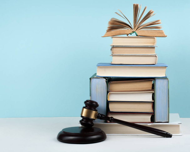 Law concept open book with wooden judges gavel on table in a courtroom or law enforcement office, blue background. Copy space for text. - Photo, Image