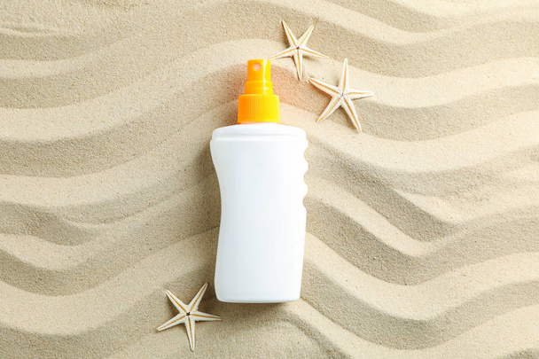 Чистый морской песок с солнцезащитным кремом и морскими звездами, пространство для текста. Су
 - Фото, изображение