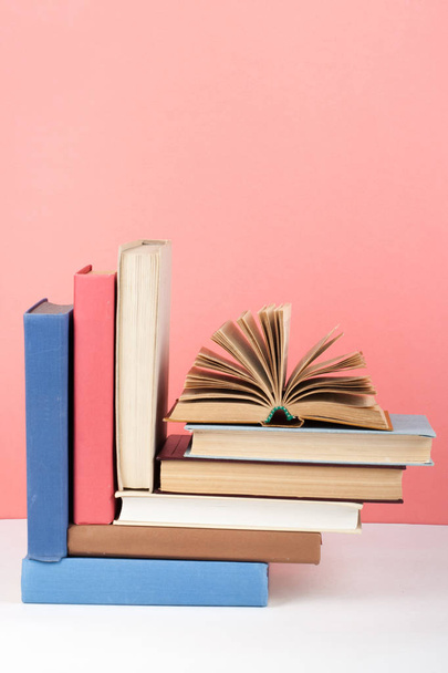 Open book, hardback colorful books on wooden table, red, pink background. Back to school. Copy space for text. Education business concept. - Φωτογραφία, εικόνα