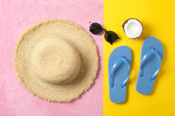 Strohhut, Flip Flops, Sonnenbrille und Kokosnuss auf zweifarbigem Backgr - Foto, Bild