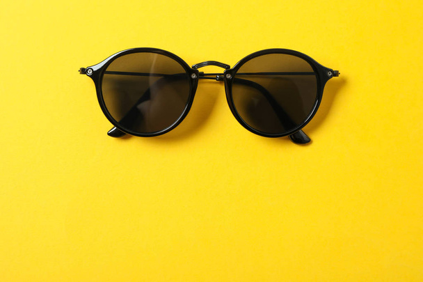 Sunglasses on color background, space for text and closeup. Fash - 写真・画像