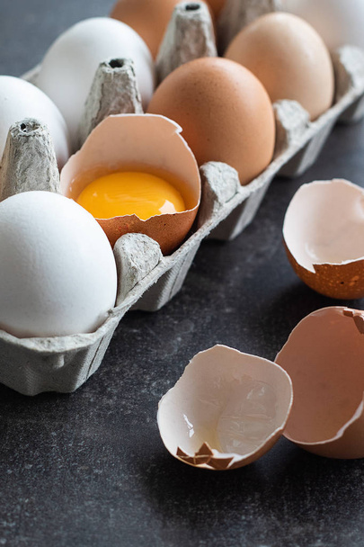 Huevos crudos orgánicos frescos, blancos, beige y marrón, uno está agrietado
 - Foto, Imagen